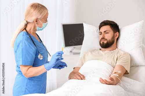 Mature female doctor working with patient in hospital room