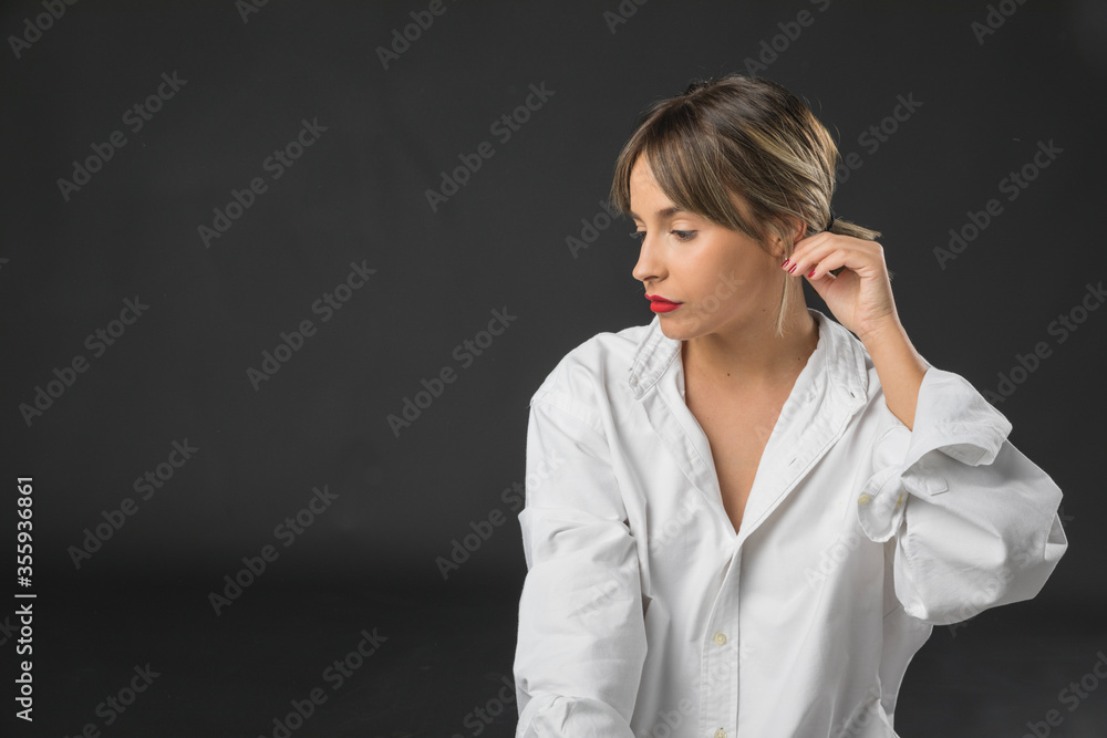 Joven modelo posando en estudio unícamente con una camisa de hombre Joven modelo posando en estudio unícamente con una camisa de hombre