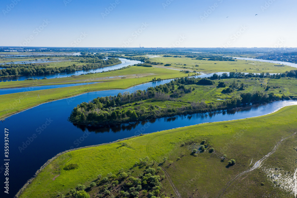Scenic aerial view of a river and green fields in a countryside