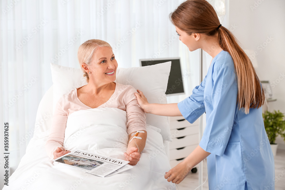 Fototapeta premium Female doctor working with patient in hospital room