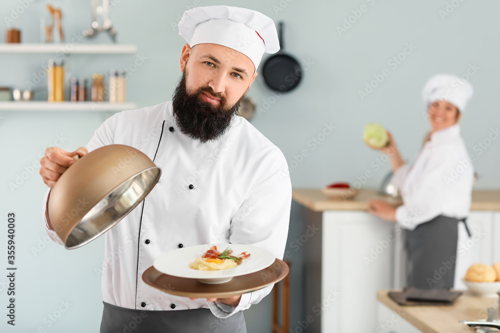 Male chef with tasty dish in kitchen Male chef with tasty dish in kitchen