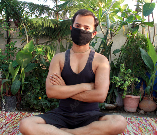 young man crossed hand and relaxing after meditation in mask