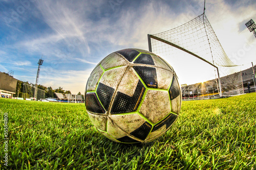 Football ball on green grass at stadium