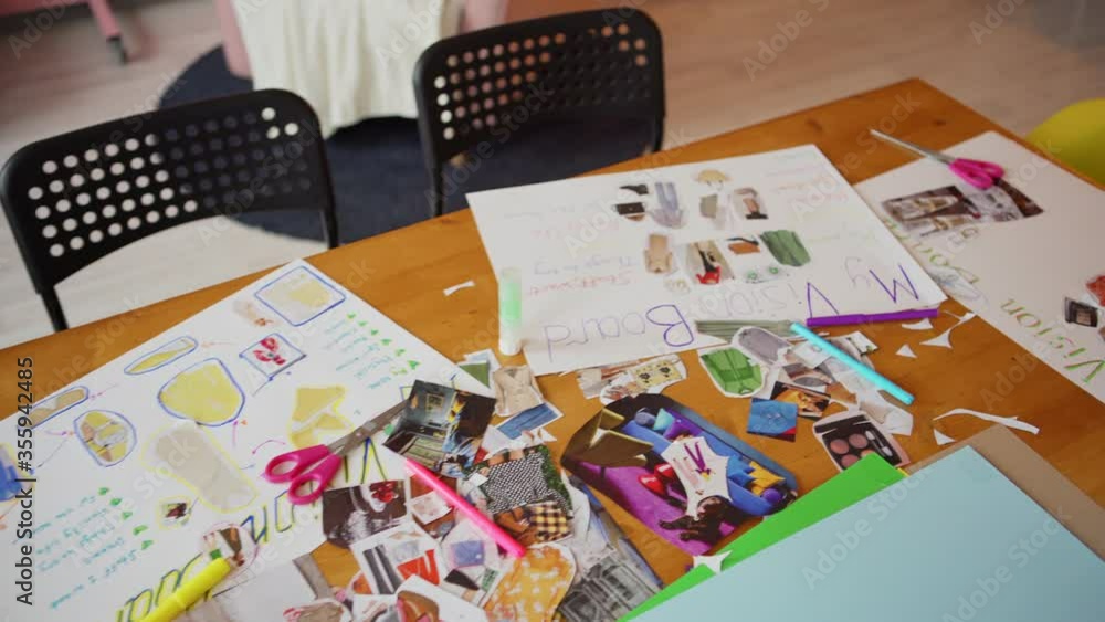 Top view panning shot of four handmade vision board collages placed on table during goal visualization training workshop Top view panning shot of four handmade vision board collages placed on table during goal visualization training workshop