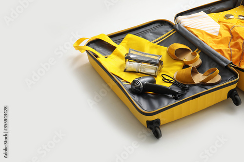 Open packed suitcase on white background