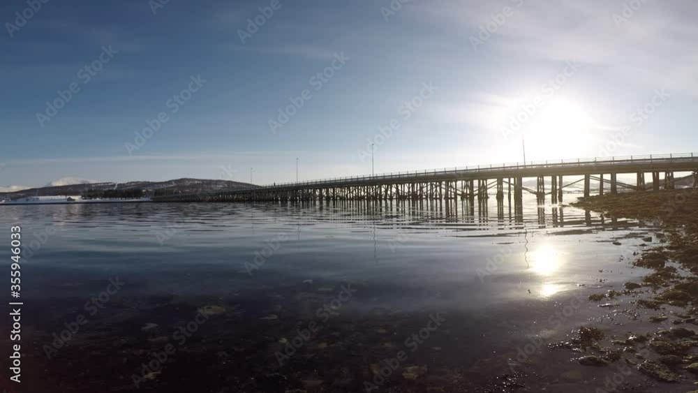 old car bridge connecting to islands with calm waves on fjord in summer