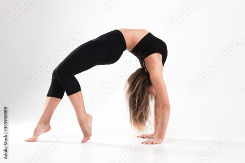 Girl in gymnastic bridge pose on a white background. Flexibility, strength, modern, stretching, classic, elegant, style, exercise, workout, beautiful, elastic, athlete