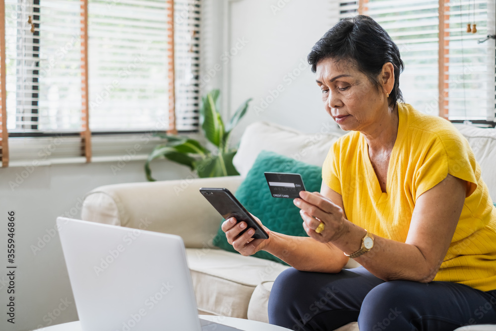 Senior Asian woman use credit card mobile phone for online shopping Senior Asian woman use credit card mobile phone for online shopping