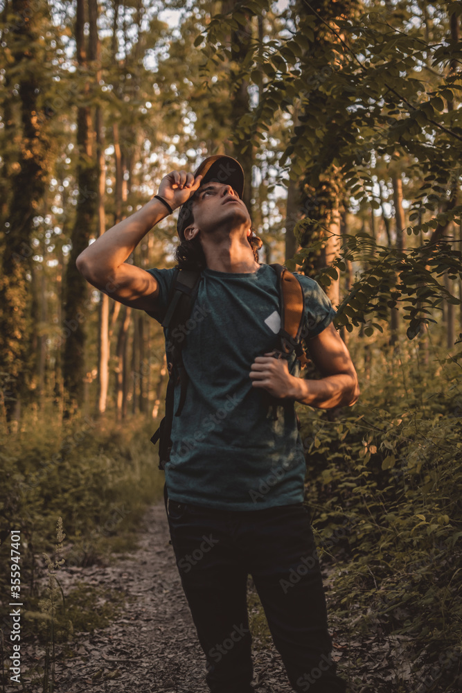 Obraz premium A young man looking around in the middle of the forest