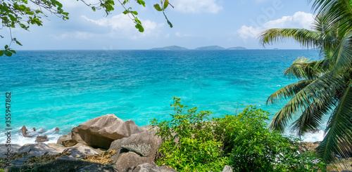 Beautiful seascape with palm tree on tropical beach, La Digue, Seychelles. Summer vacation and travel concept. panoramic seascape © mathilde