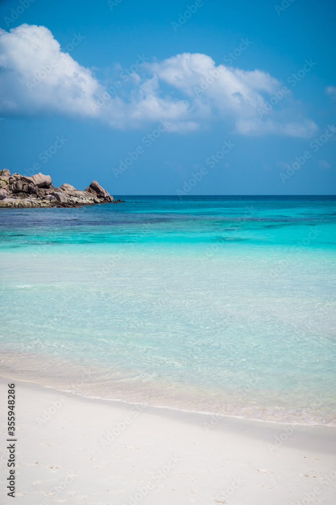 Beautiful beach. View of nice tropical sandy beach with famous granite rocks on Anse Coco beach, La Digue Island, Seychelles. Holiday and vacation concept. Tropical beach on background blue sky