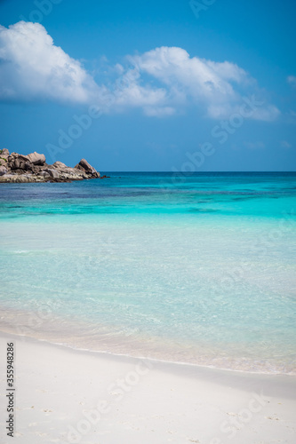 Beautiful beach. View of nice tropical sandy beach with famous granite rocks on Anse Coco beach, La Digue Island, Seychelles. Holiday and vacation concept. Tropical beach on background blue sky
