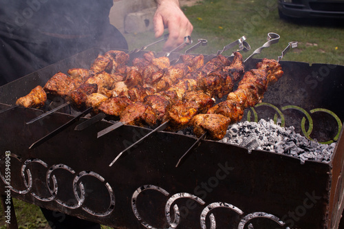 shish kebab in the open air on the grill.cooking meat on the street. street food. picnic. family rest. meat on the shampoo. heat from roast meat. heat from coals on the grill. Shish kebab from chicken