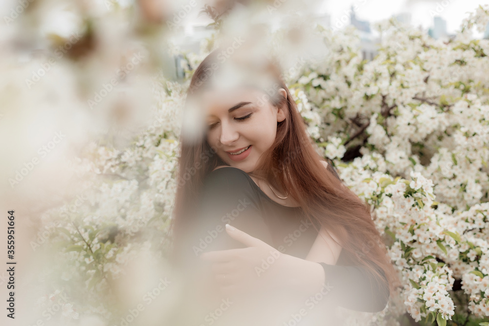 Beautiful girl in white flowers. Woman posing in white flowers.