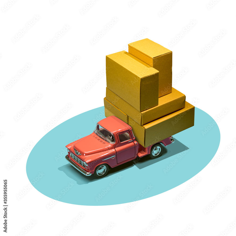 Fast order delivery by car concept. Pickup truck delivering blank boxes. Loaded retro toy car loaded with cardboard packages isolated on white background. Fast order delivery by car concept. Pickup truck delivering blank boxes. Loaded retro toy car loaded with cardboard packages isolated on white background.