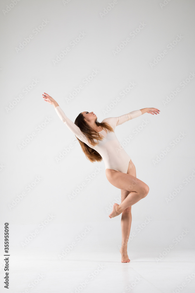 Fototapeta premium Ballerina in a dance unusual pose on a white background. Art, style, background, elegant, expensive, luxury, amazing, modern.
