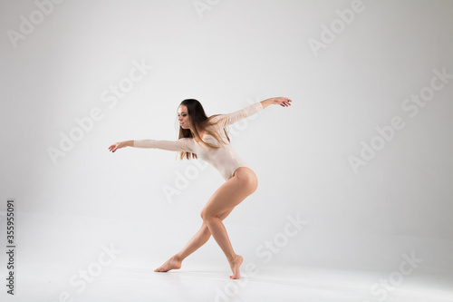 Female beautiful dancer in a dance unusual pose on a white background. Art, style, background, elegant, expensive, luxury, amazing, modern.