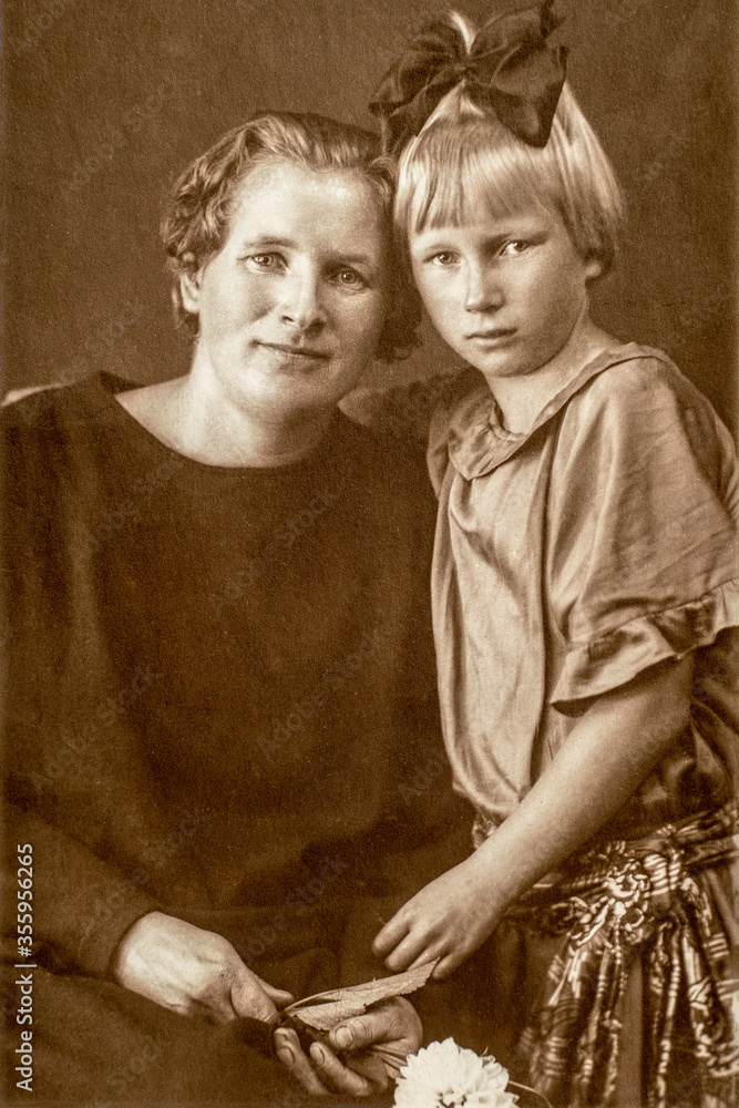 Germany CIRCA 1930s Portrait Of Mother And Daughter Sitting At Bench Germany CIRCA 1930s Portrait Of Mother And Daughter Sitting At Bench