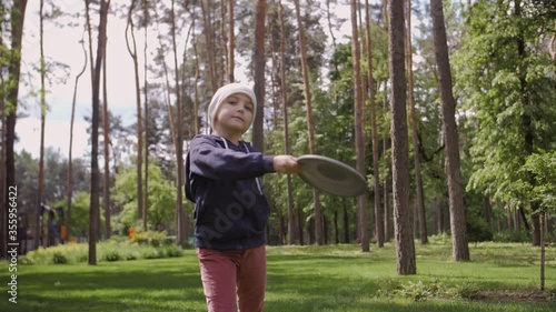 Slow Motion Shot Of A Cute Girl Throwing A Frisbee photo