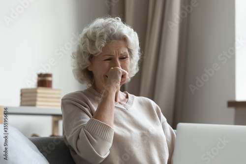 Foto Upset stressed elderly 50s woman feel distressed reading unpleasant negative mes