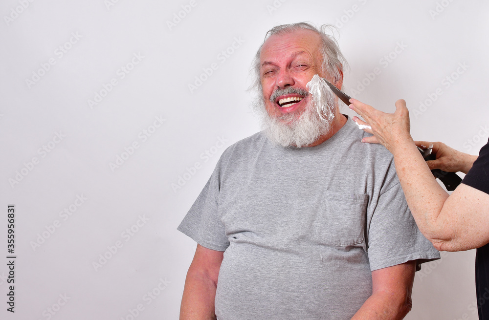 Scared man is getting a shave from a woman using a huge hunting knife..Self isolated man getting  a primitive shave with a large knife.