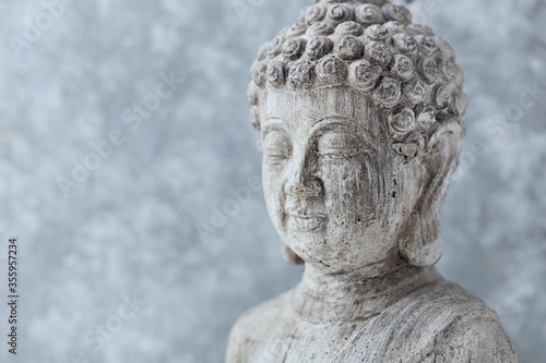 Meditating Buddha Statue on bright background. Copy space. 