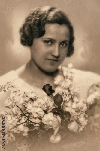 Latvia - CIRCA 1937: Wedding portrait of female with flowers in studio, Vintage Carte de Viste Art Deco era photo photo