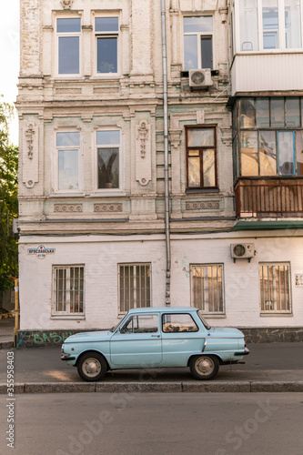 Kyiv (Kiev), Ukraine - June 07, 2020: An old blue car (ZAZ Zaporozhets) which was very popular in 1980s in front of a prerevolutionary building  © Bohdan