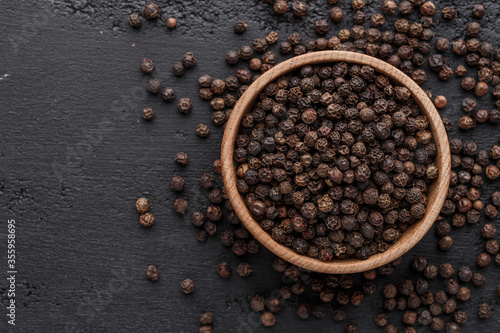 Peppercorn background. Dry black pepper seeds. Top view.On a black background. free space for your text.