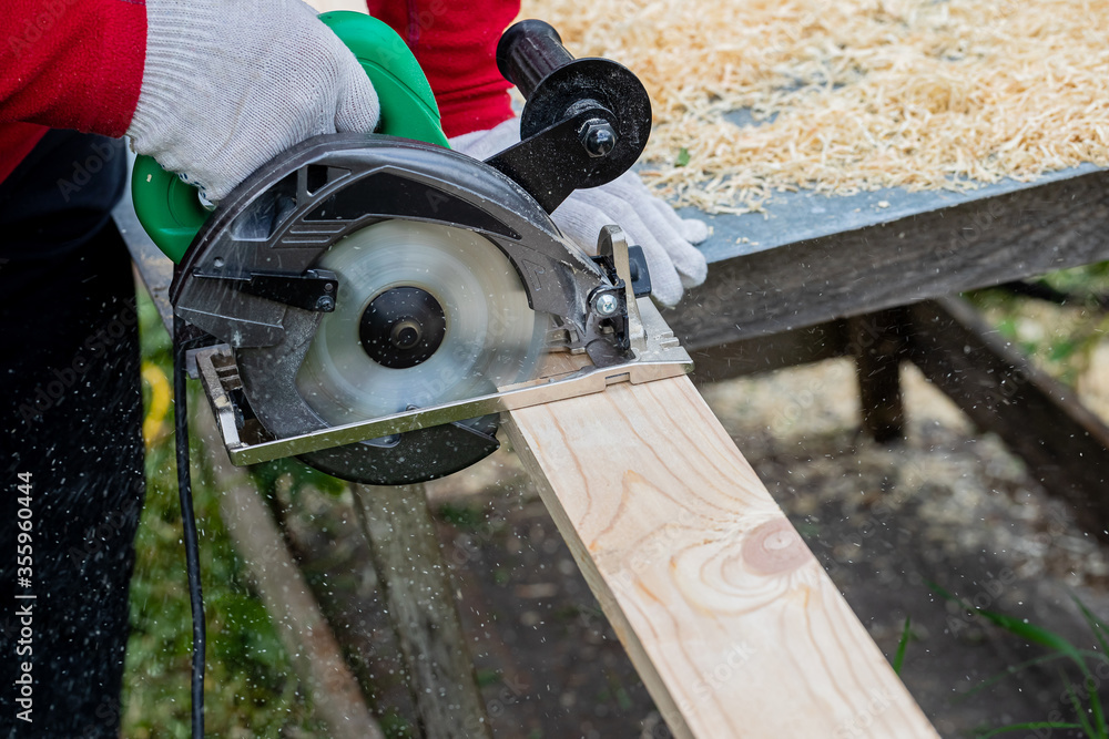Male carpenter sawing wooden boards. Male carpenter sawing wooden boards.