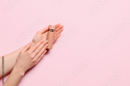 Female hands with perfume on color background © Pixel-Shot