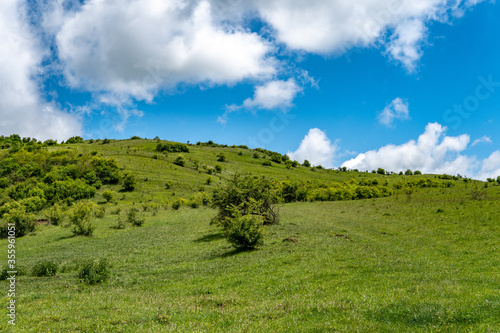 Tranquil Hilltop Landscape with Blue Sky and Clouds
