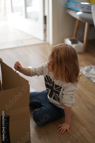 girl painting on a box in self-isolation