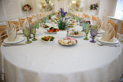A sumptuous long table with food for those invited to the feast. Serving and design of a festive dinner for a Banquet in a restaurant.