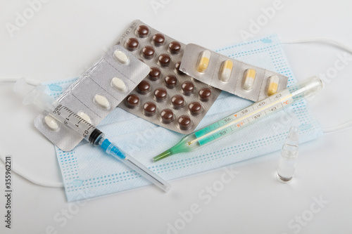 tablets with medications are on a protective medical mask on the table.