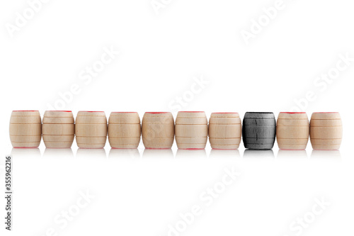 small wooden barrels stand in a row, one highlighted in black.