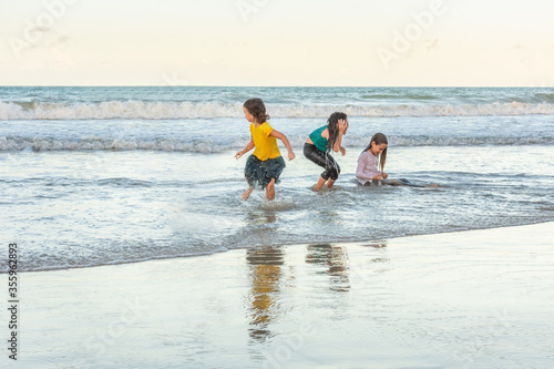 Children friends playing relaxed on the beach on a beautiful day