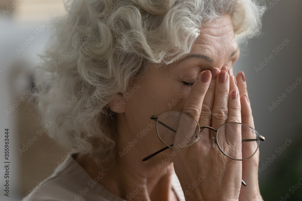 Close up of tired elderly woman rub massage eyes take off glasses suffering from headache or migraine, exhausted mature 60s female have dizziness or blurry vision form high blood pressure - obrazy, fototapety, plakaty 