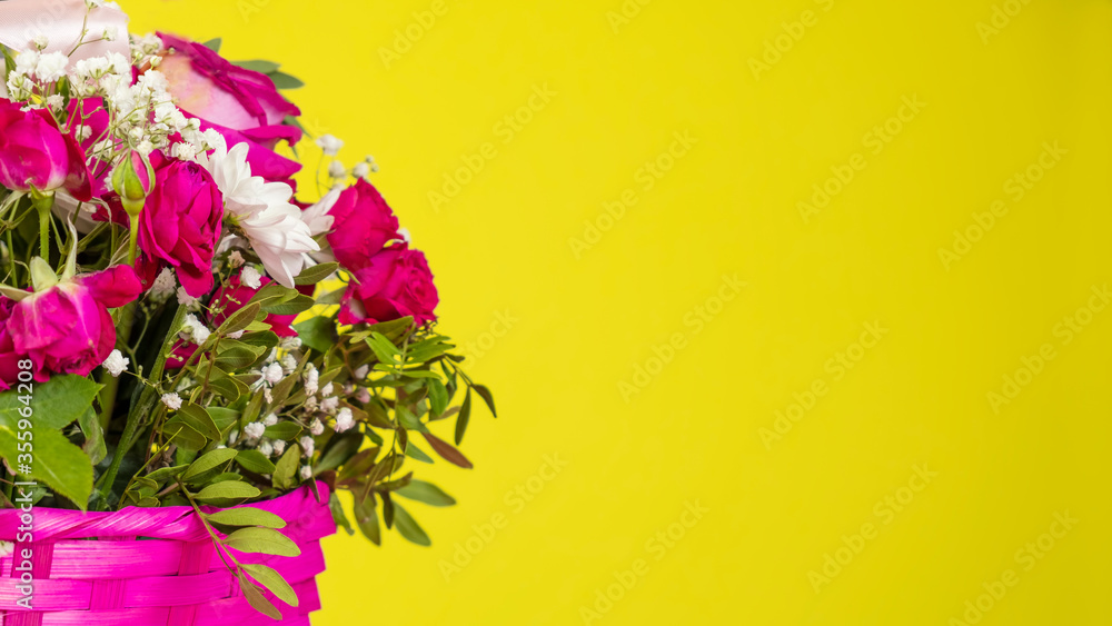 Bouquet with flowers in a basket  on yellow background. Text space