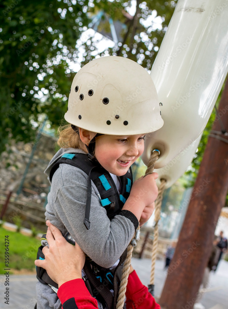 Little girl having fun while climbing in adventure park Little girl having fun while climbing in adventure park