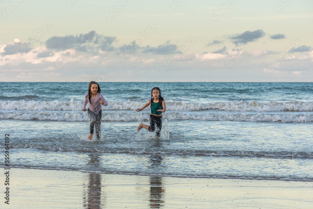 Children running on the beach juggling joy Children running on the beach juggling joy
