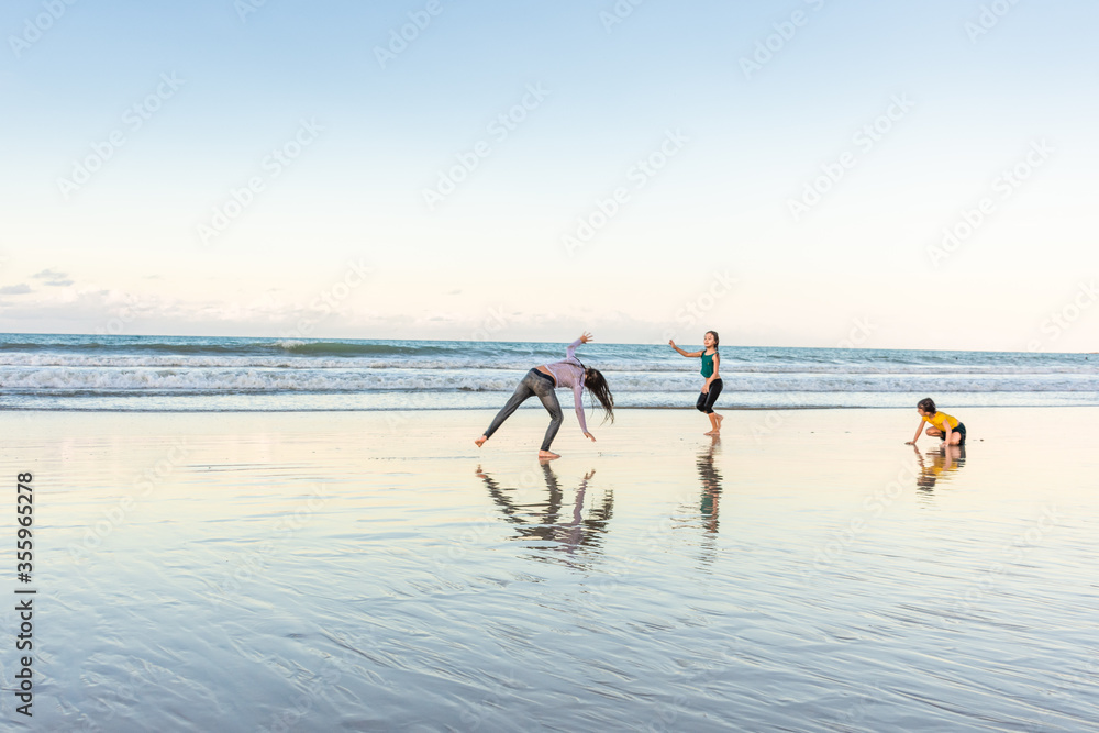 Children exercising on the beach juggling joy