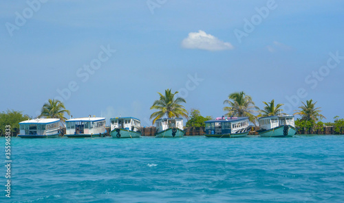 Idyllic view of a fleet of boats moored by a picturesque tropical island. © helivideo