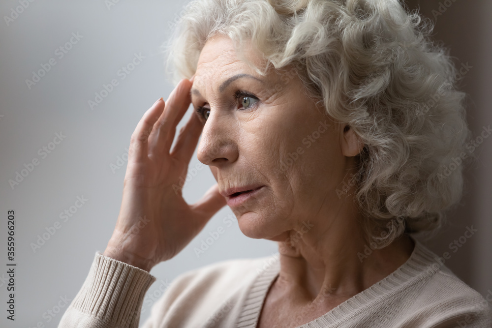 Upset anxious senior woman lost in thoughts feel nostalgic melancholic at home, sad mature 60s female look in distance thinking or pondering alone in retirement house, elderly solitude concept Upset anxious senior woman lost in thoughts feel nostalgic melancholic at home, sad mature 60s female look in distance thinking or pondering alone in retirement house, elderly solitude concept