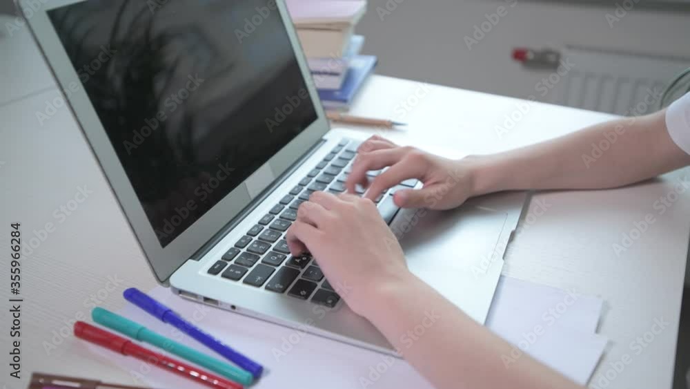 The guy is typing on a laptop. Multi-colored felt-tip pens, books on the table The guy is typing on a laptop. Multi-colored felt-tip pens, books on the table
