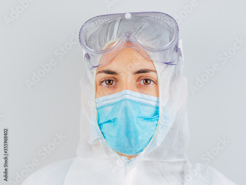 Caucasian woman doctor in uniform, medical cap and mask, close-up portrait.
