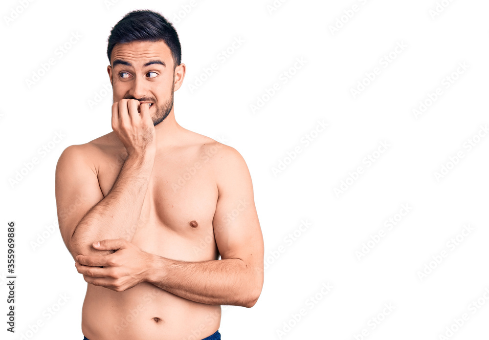 Fototapeta premium Young handsome man wearing swimwear looking stressed and nervous with hands on mouth biting nails. anxiety problem.