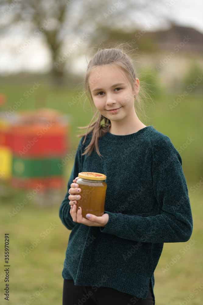 A young beekeeper girl is working with bees A young beekeeper girl is working with bees