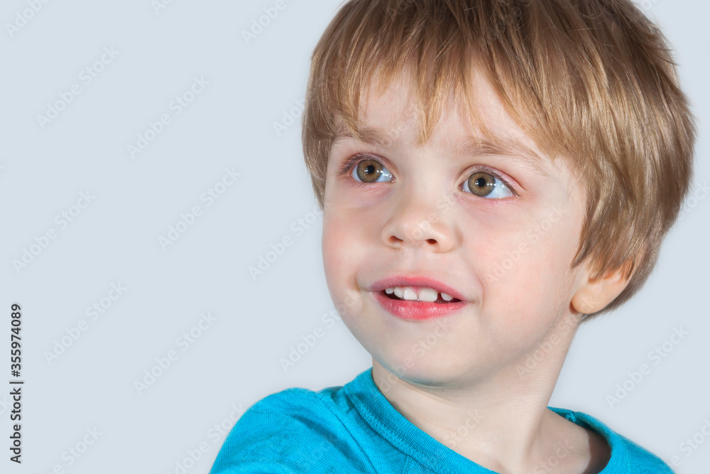 Child looking carefully with interest and smiling. Light background. (concept Child looking carefully with interest and smiling. Light background. (concept