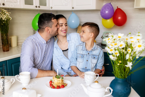 Happy family celebrates birthday at home in the kitchen.